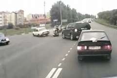 停車した車の間をすり抜けたバイクが左折車に突っ込む