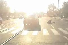 太陽の逆光が眩しい道路で横断歩道を横断中の歩行者が車に撥ねられる