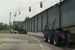 巨大な鉄柱を牽引していたトラックが横転する