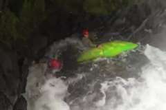 激流が押し寄せる岩のくぼみから自力脱出できないカヤッカーを救助する