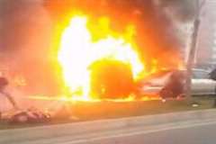 大炎上している車の付近で救助や消火活動をする人達