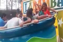 遊園地の回転式遊具から振り落とされる女性