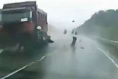 雨の路面でコントロールを失った車が対向車のトラックと衝突し大破する