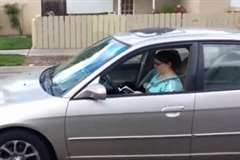 車を運転しながら本を読んでいる女性ドライバー