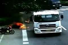 スクーターがトラックに轢かれて炎上し運転していた女性に燃え移る
