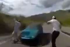 間一髪で車との激突を回避するスケートボーダー