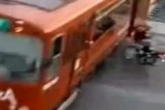 踏み切り内で走行中の列車の側面にバイクが突っ込んでくる