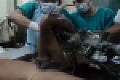 男性の足に絡まるように突き刺さった機械の一部を取り除く