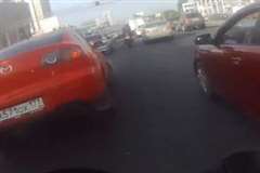 渋滞の車列をすり抜けていたバイクが突然バックした車に衝突！