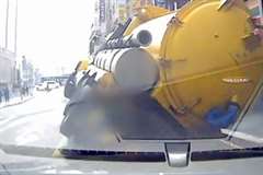 突然の道路陥没でトラックが横倒しとなる