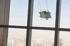 高層ビルの最上階付近で窓拭き用のゴンドラが突風に煽られ大変な事に！