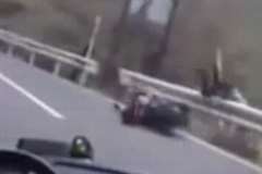 ガードレールの外側へと投げ出されるライダー