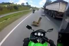 道路の落下物を踏み転倒するバイク